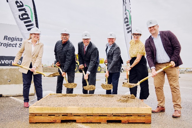 A photo of Cargill staff and local government with hard hats and shovels, shovelling dirt to signify the breaking of ground on Project Queen